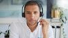 Mitarbeiter mit Headset sitzt in einem hellen Büro und ist im Kundenservice im Einsatz