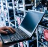 IT Systemadministrator arbeitet mit einem Laptop an der IT Infrastruktur im Serverraum
