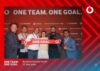 Gruppenbild von sechs Personen beim Vodafone Business Partner Forum mit rotem Hintergrund