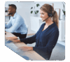 Mitarbeiterin arbeitet mit VoIP-Telefonanlage am Schreibtisch und trägt ein Headset